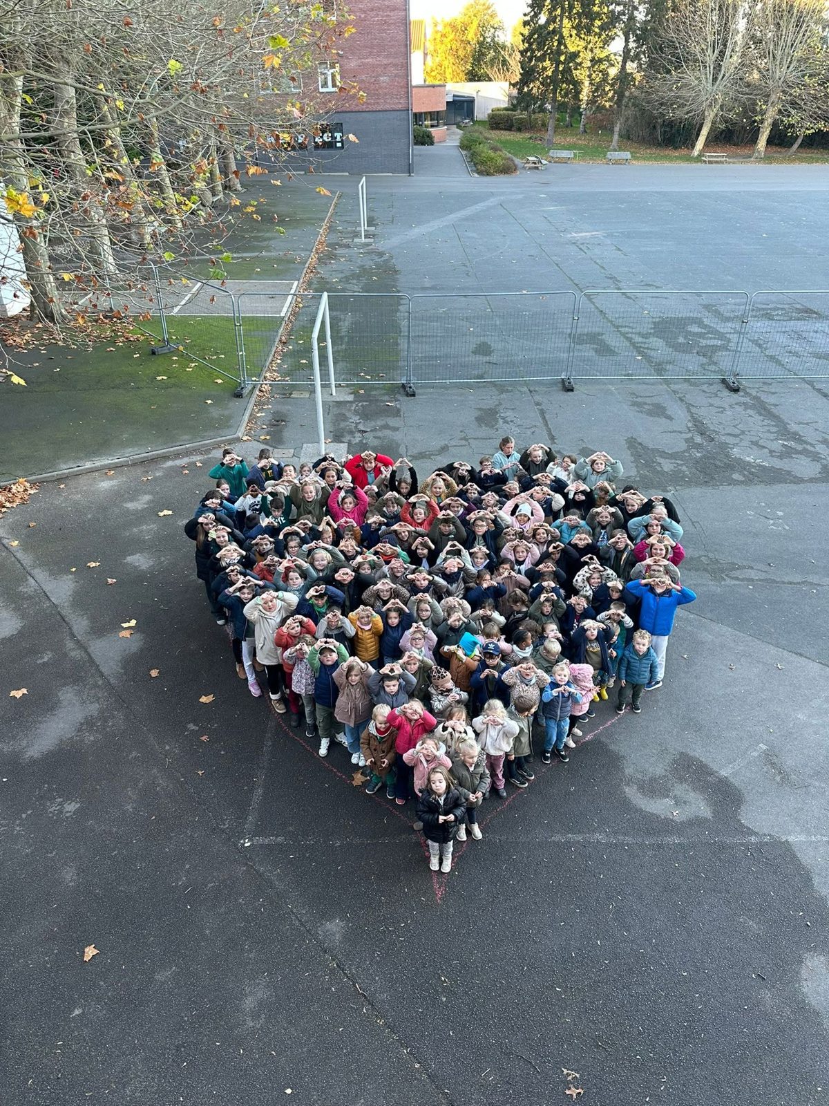 Vus du ciel, les élèves de l'école forment un grand cœur dans la cour
