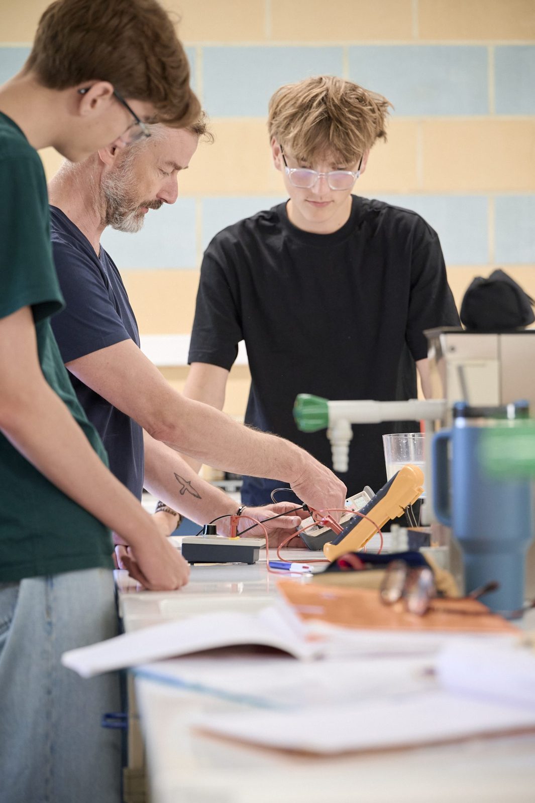 Des lycéens réalisent une expérience de physique avec leur professeur